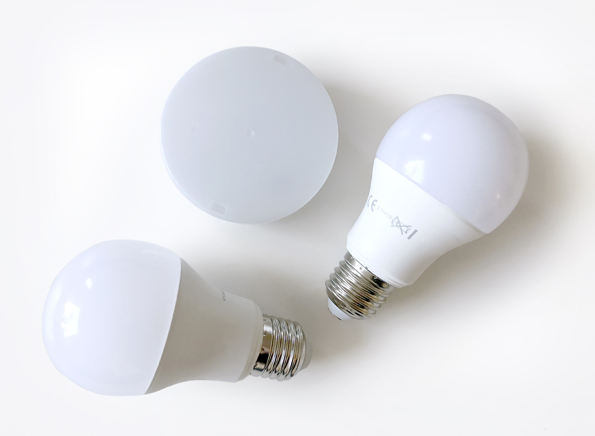 Three white LED light bulbs on a table.
