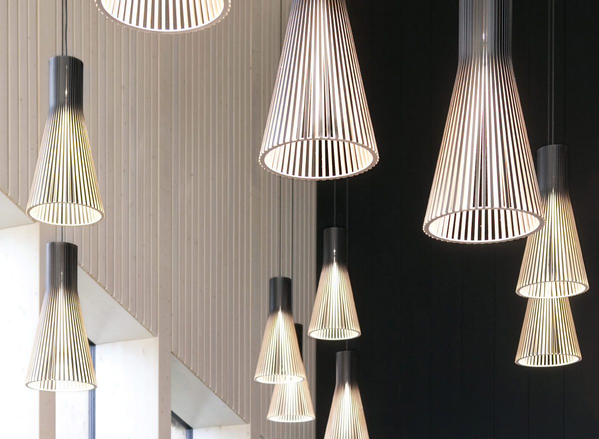 A close-up of black Secto pendant lamps hanging from the ceiling.