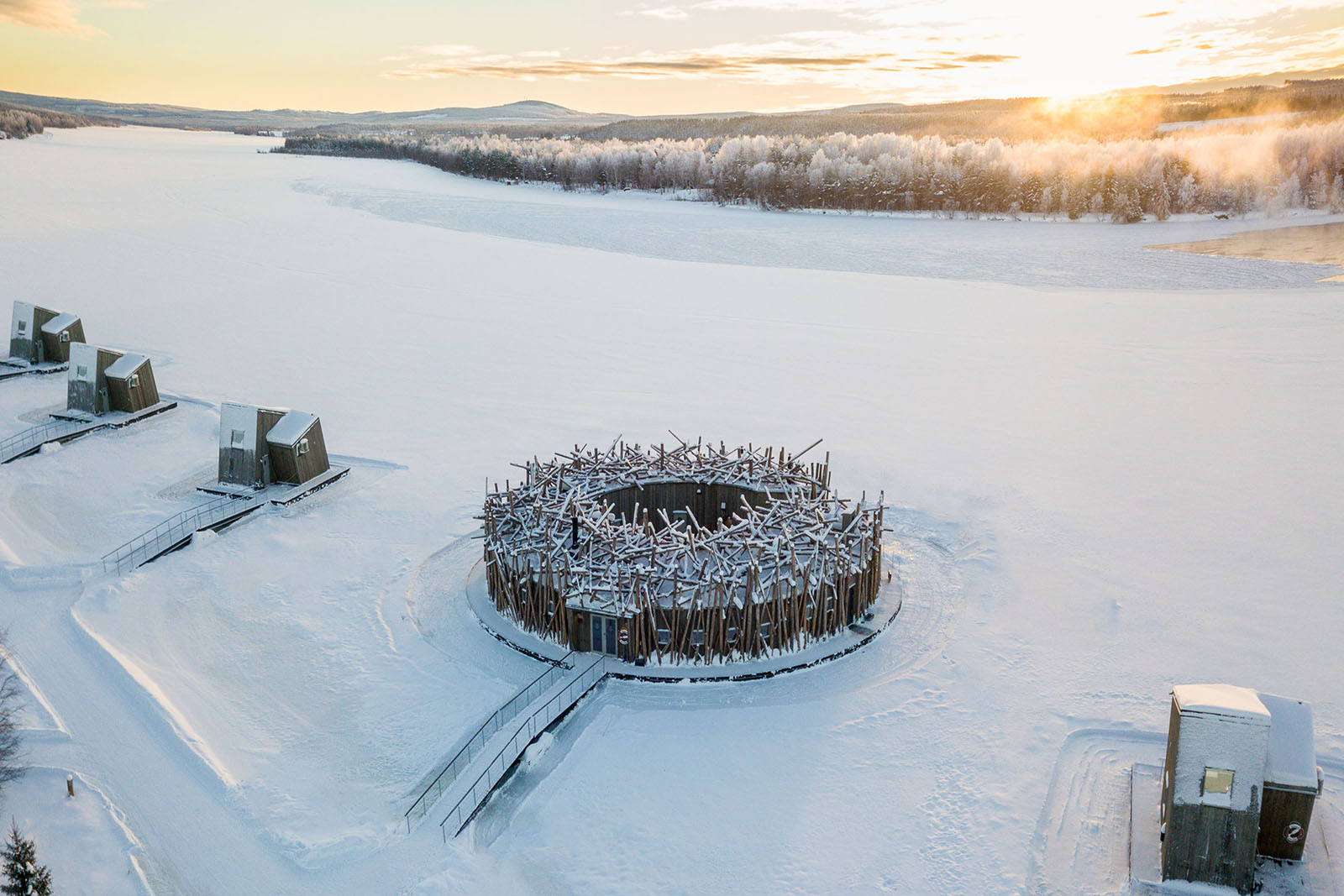 Luftaufnahme des kreisförmigen Hauptgebäudes des Arctic Bath Hotels auf dem Fluss Lule in Schweden.