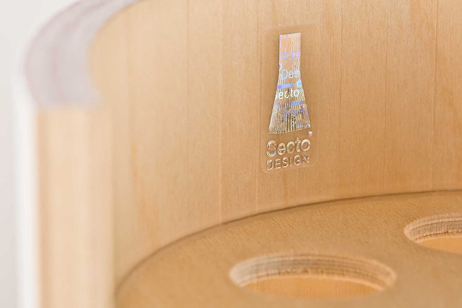 Nahaufnahme eines Hologramm-Echtheitslabels an einer Pendelleuchte aus Holz.