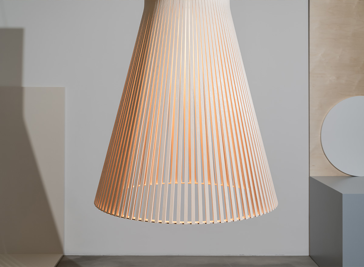 The lower half of the Magnum pendant lamp in birch on a grey modern background.