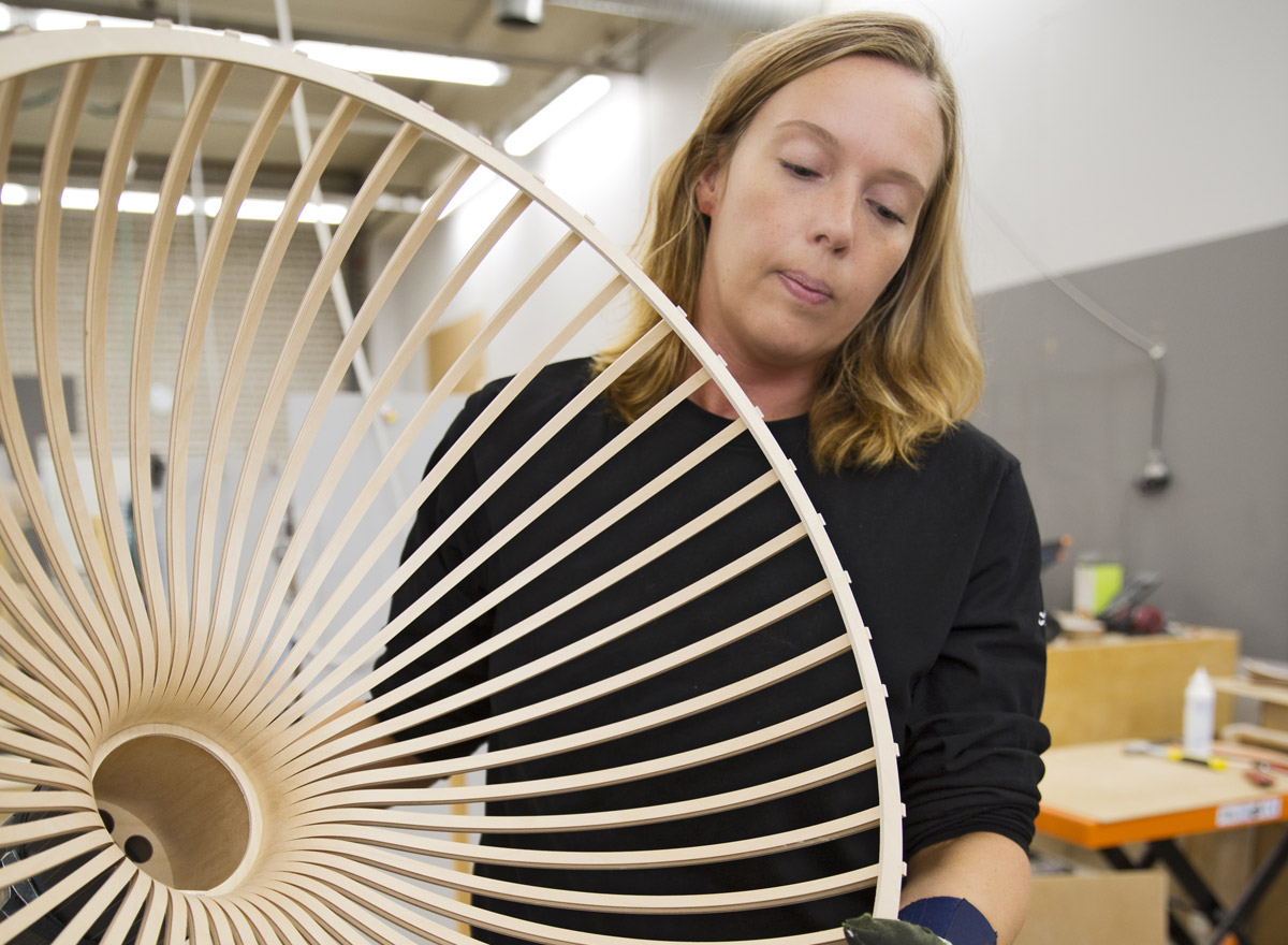 A female factory employee holding a Victo pendant lamp.