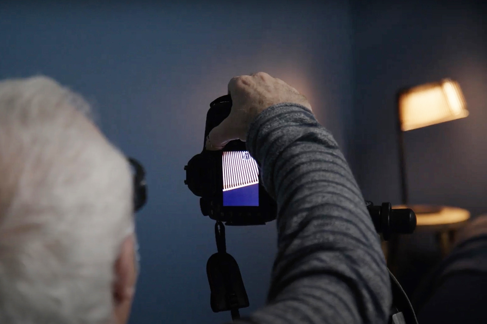 Un photographe réglant sa caméra dans une pièce obscure.