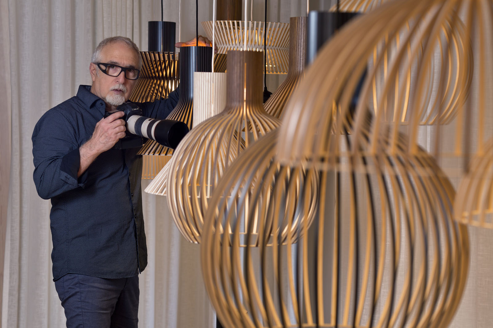 Photographe à côté d’un groupe de lampes Secto Design.