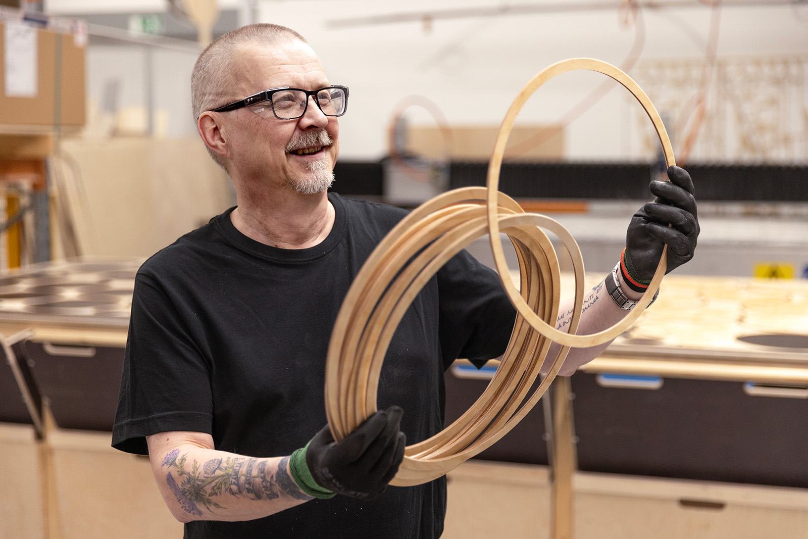 A man holding and looking at wooden rings. 