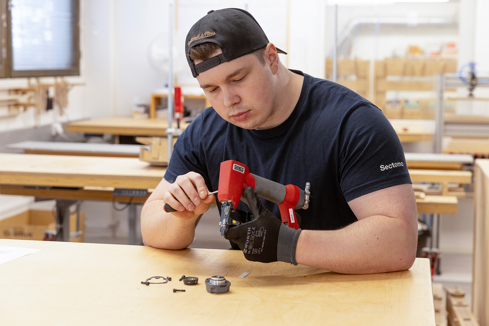 A man servicing a nail gun. 