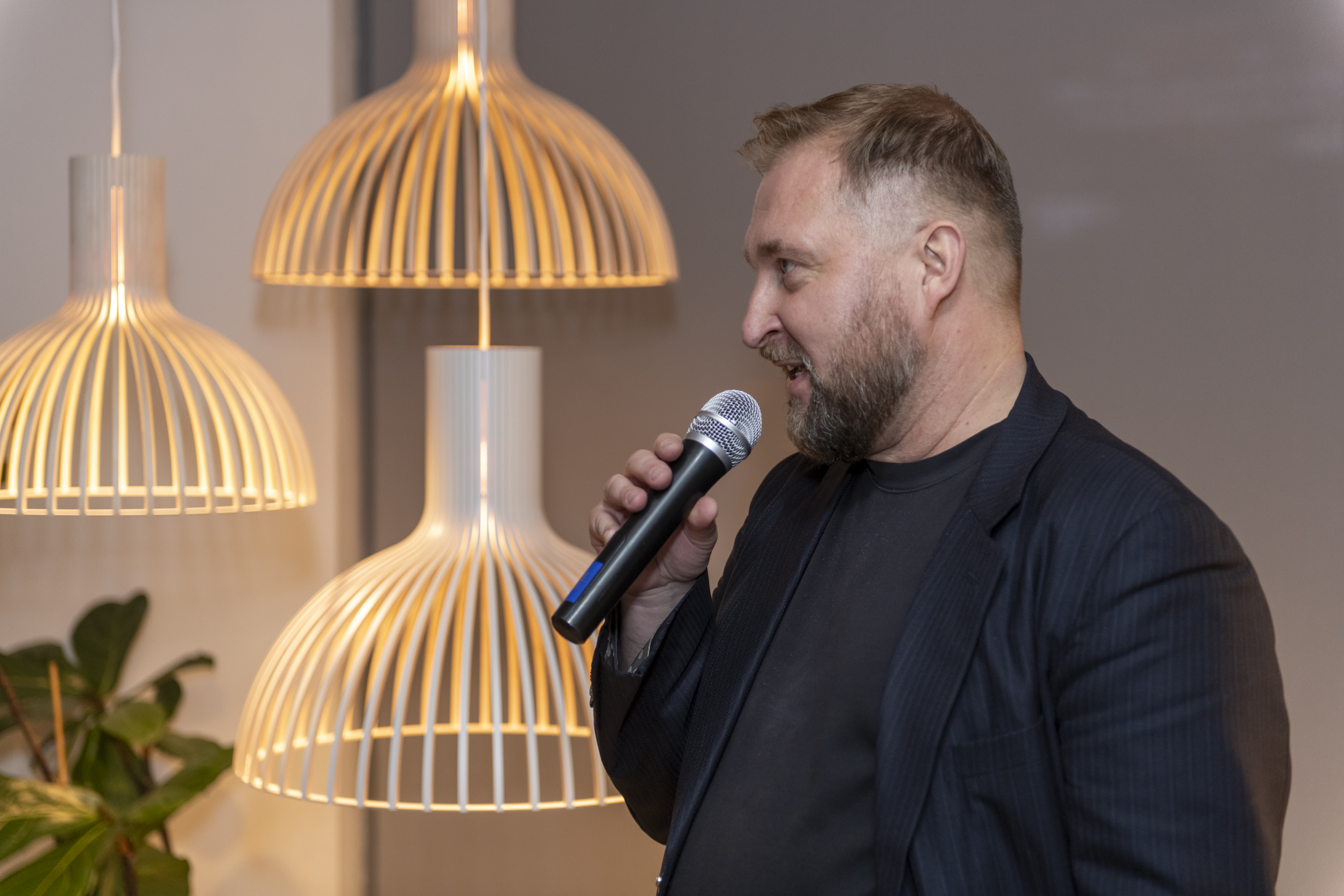 A man talking with a microphone on his hand.