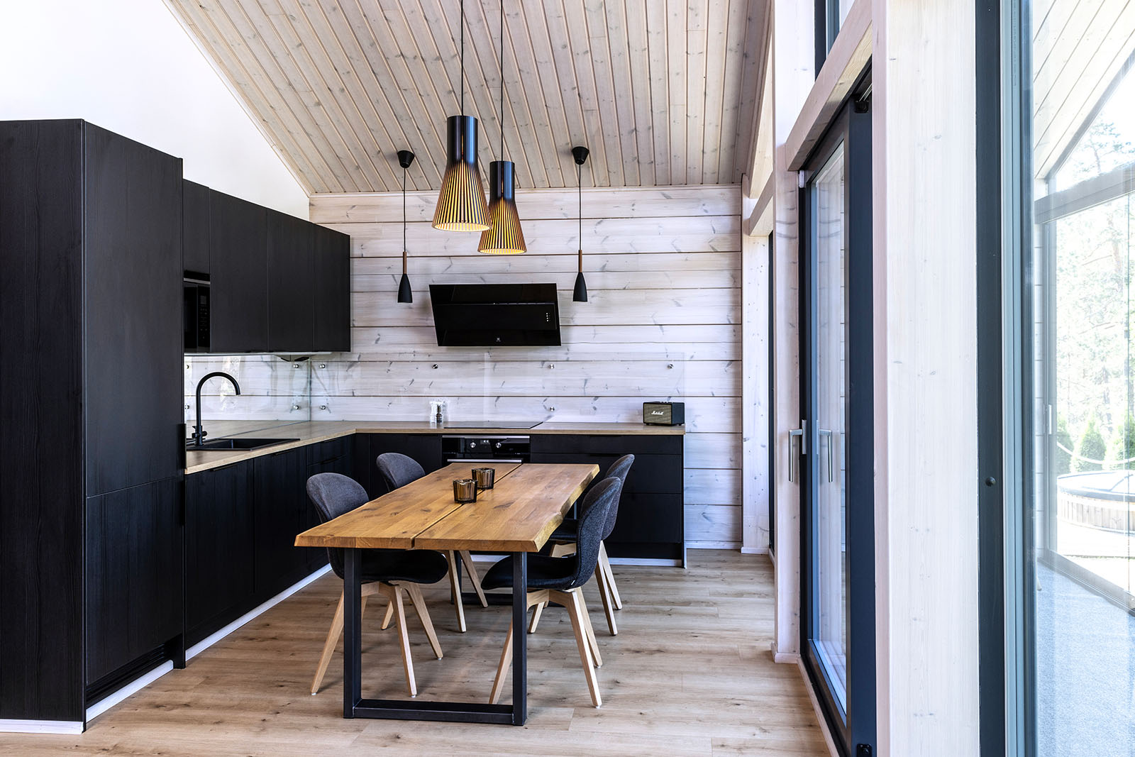 A kitchen with two pendant lamps above a dining table.